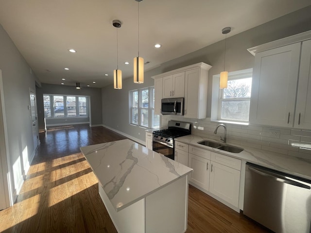 kitchen featuring light stone counters, white cabinetry, sink, and appliances with stainless steel finishes