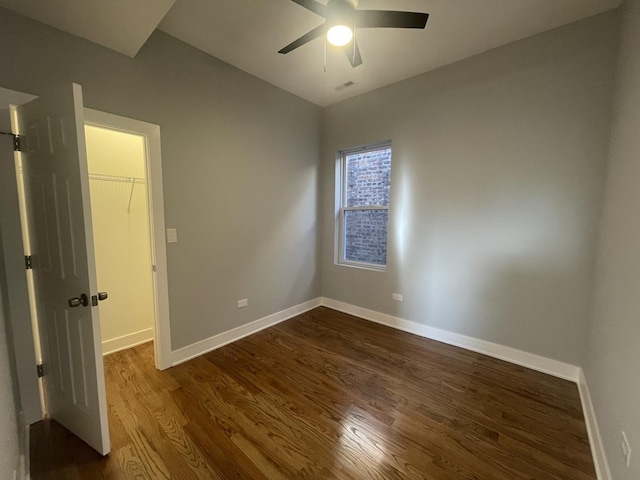 unfurnished room with ceiling fan and dark wood-type flooring