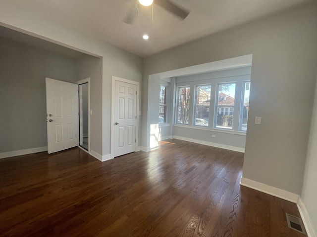 unfurnished room featuring ceiling fan and dark hardwood / wood-style flooring