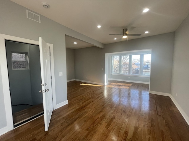 unfurnished living room with ceiling fan and dark wood-type flooring