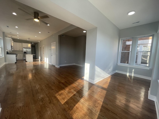 unfurnished living room with ceiling fan and dark wood-type flooring