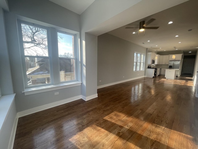 unfurnished living room featuring ceiling fan and dark hardwood / wood-style floors