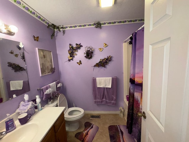 bathroom with vanity, tile patterned flooring, toilet, walk in shower, and a textured ceiling