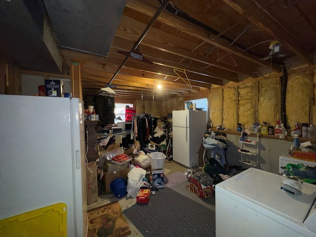 basement featuring washer / dryer and white refrigerator