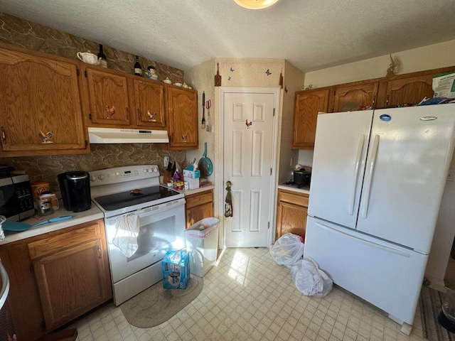 kitchen featuring a textured ceiling, white appliances, and backsplash