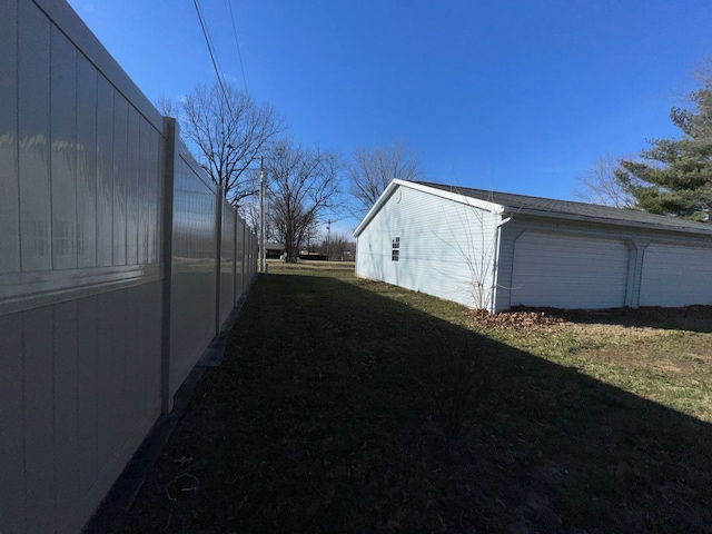 view of side of property with a lawn and a garage