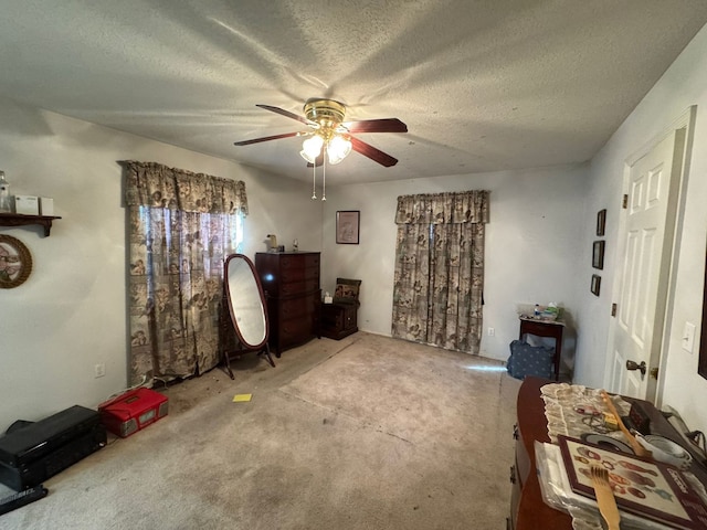 misc room featuring carpet flooring, ceiling fan, and a textured ceiling