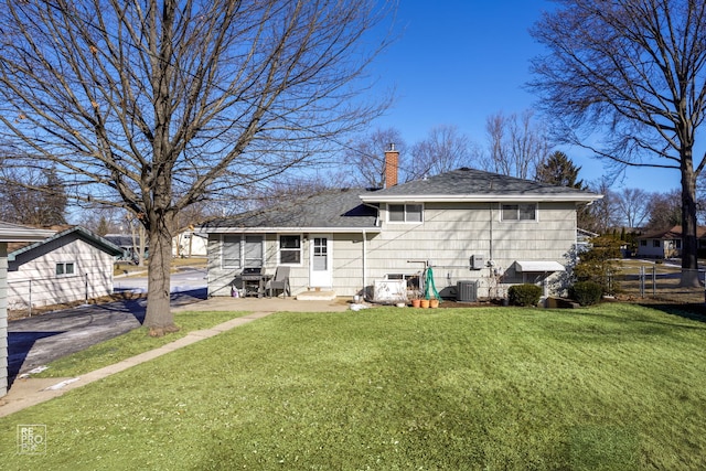 rear view of property with a yard and central AC