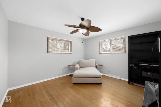 living area featuring ceiling fan and light hardwood / wood-style flooring