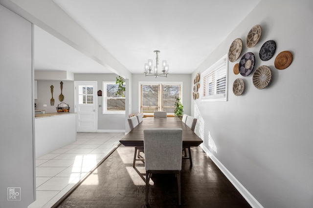 dining area with light tile patterned flooring and a notable chandelier