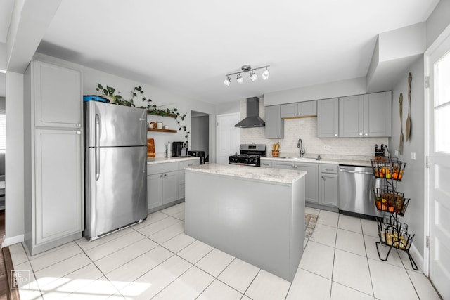 kitchen with a kitchen island, sink, gray cabinetry, stainless steel appliances, and wall chimney exhaust hood