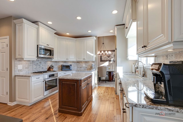 kitchen featuring light stone countertops, appliances with stainless steel finishes, and white cabinetry