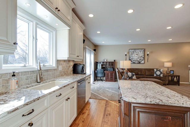 kitchen featuring sink, white cabinetry, dishwasher, and light stone counters