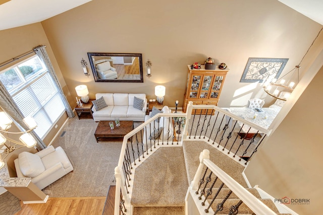 staircase with hardwood / wood-style floors and a notable chandelier