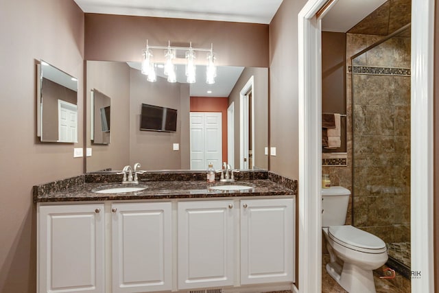 bathroom with tile walls, a tile shower, vanity, and toilet