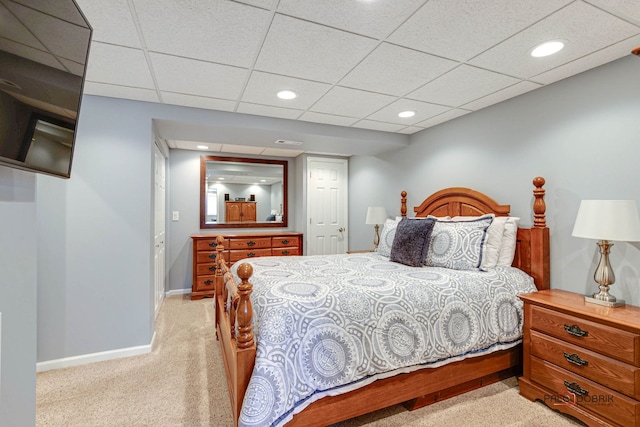 bedroom featuring a paneled ceiling and light carpet