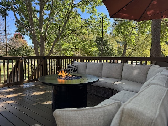 wooden deck with an outdoor living space with a fire pit