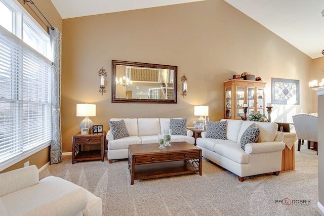 living room with a notable chandelier, light colored carpet, and vaulted ceiling