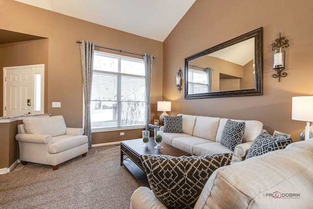 living room featuring lofted ceiling, carpet flooring, and a healthy amount of sunlight