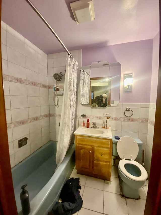 full bathroom with shower / bath combo, vanity, tile patterned flooring, toilet, and tile walls