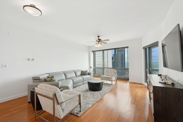 living room with ceiling fan and light hardwood / wood-style flooring