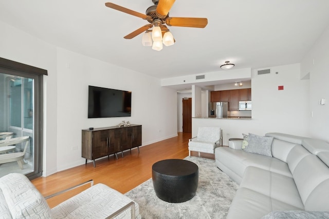 living room with ceiling fan and light wood-type flooring