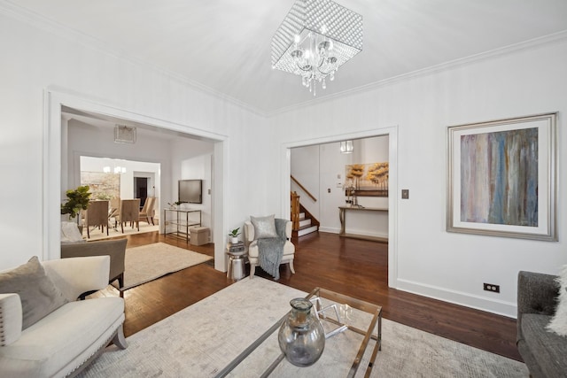 living room with crown molding, dark wood-type flooring, and a notable chandelier