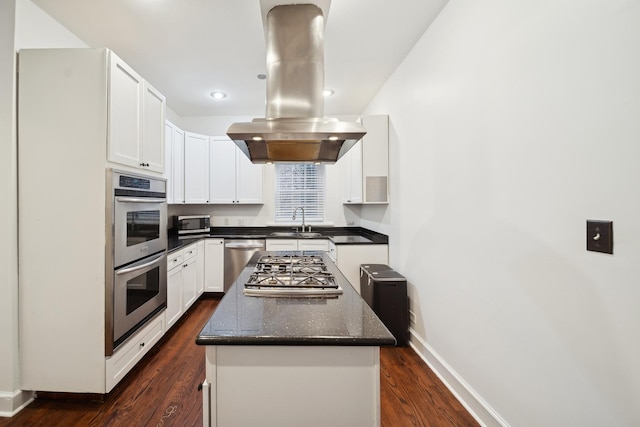 kitchen with island exhaust hood, sink, a kitchen island, white cabinets, and stainless steel appliances