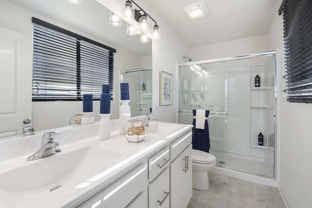 bathroom featuring tile patterned flooring, vanity, toilet, and a shower with shower door