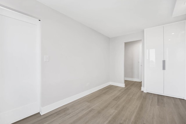 unfurnished bedroom featuring a closet and light wood-type flooring