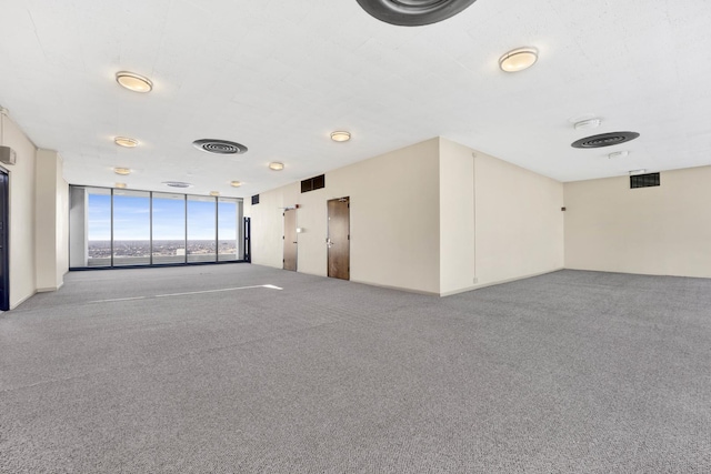 carpeted spare room with floor to ceiling windows