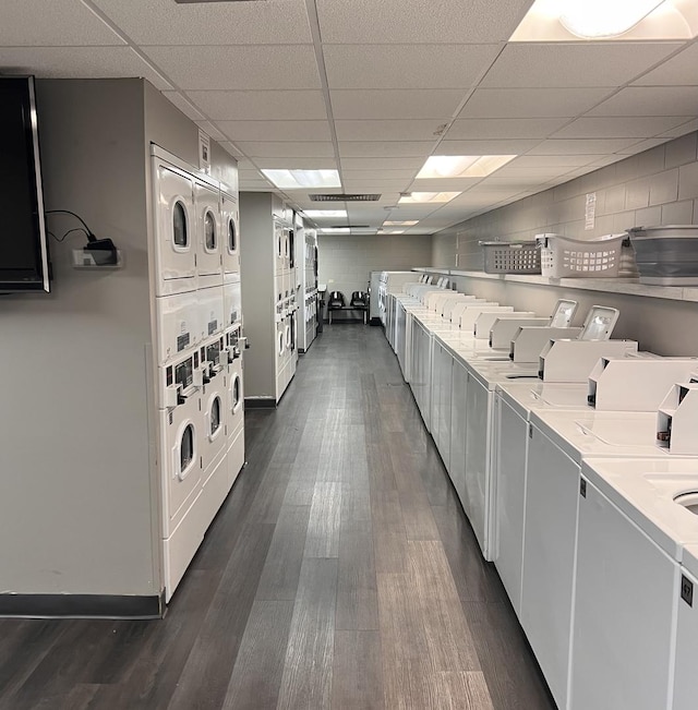 laundry area featuring dark hardwood / wood-style floors, stacked washer and dryer, and washing machine and clothes dryer