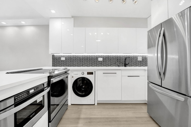 laundry room featuring washer / dryer, light wood-type flooring, and sink