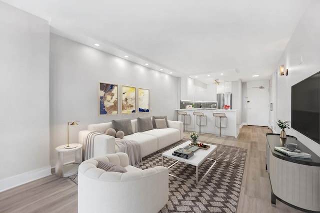 living room featuring light hardwood / wood-style flooring and ceiling fan