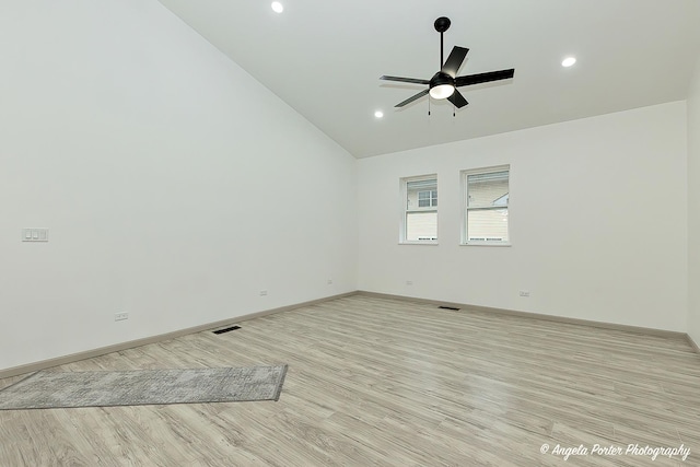 empty room featuring ceiling fan, high vaulted ceiling, and light hardwood / wood-style flooring