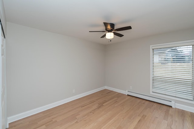 unfurnished room featuring ceiling fan, a baseboard heating unit, and light wood-type flooring