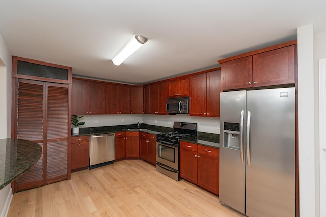 kitchen featuring appliances with stainless steel finishes and light hardwood / wood-style flooring