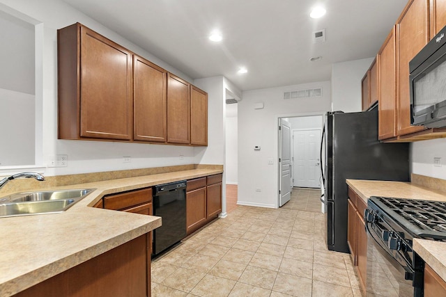 kitchen with light tile patterned floors, sink, and black appliances