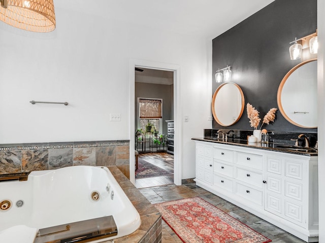 bathroom with tiled tub and vanity