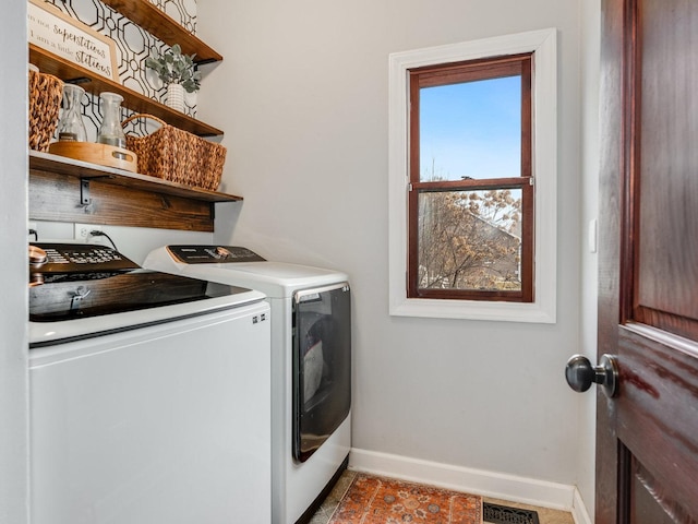 washroom with laundry area, baseboards, separate washer and dryer, and visible vents