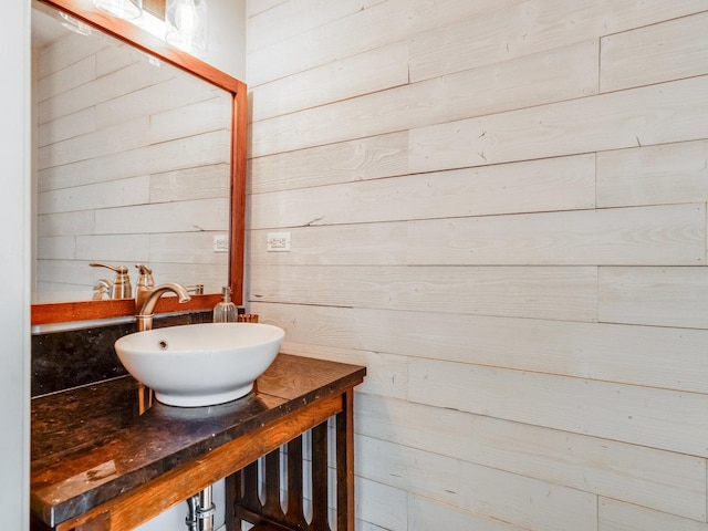bathroom with vanity and wood walls