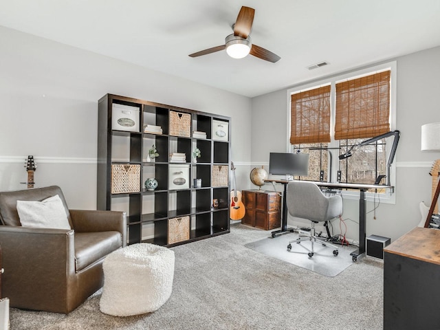 carpeted home office with ceiling fan and visible vents