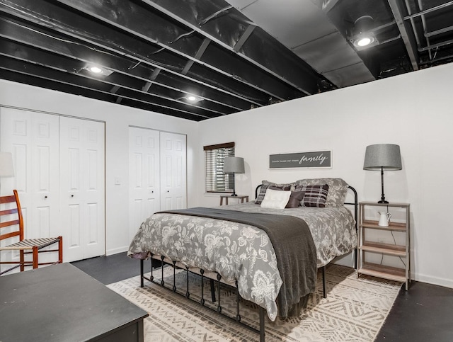 bedroom with baseboards and multiple closets