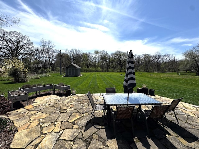 view of patio / terrace with an outbuilding, outdoor dining area, and a storage unit