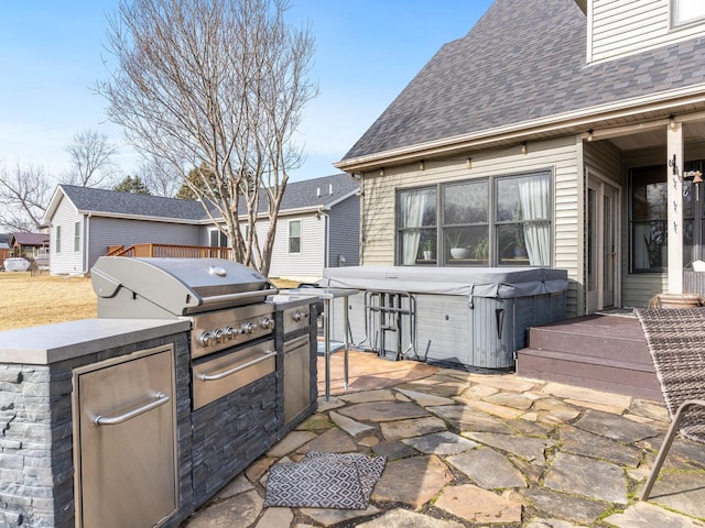 view of patio with a hot tub and exterior kitchen