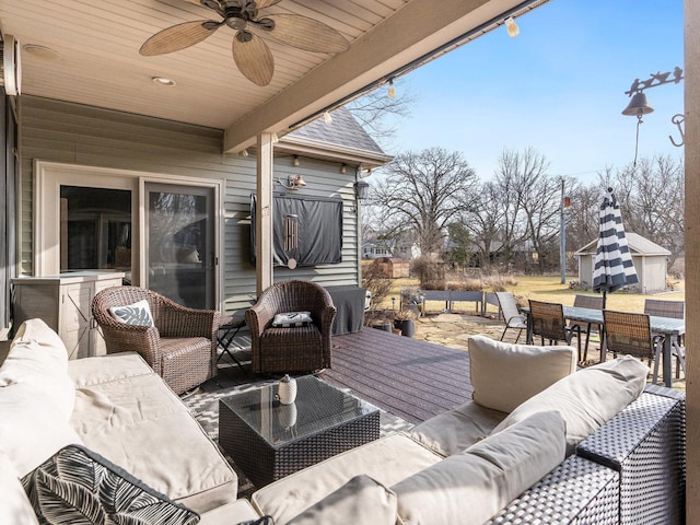 wooden deck featuring a patio, a ceiling fan, outdoor lounge area, and an outdoor structure