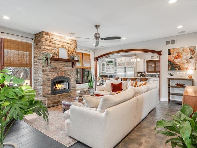 living room featuring ceiling fan and a fireplace