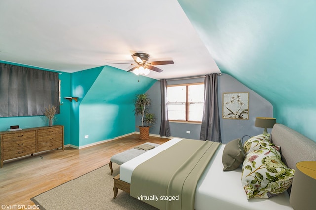 bedroom featuring light wood-type flooring, vaulted ceiling, and ceiling fan