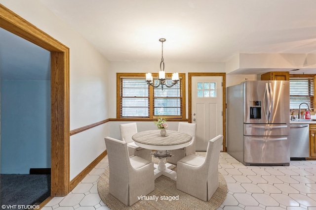 dining area with an inviting chandelier and sink