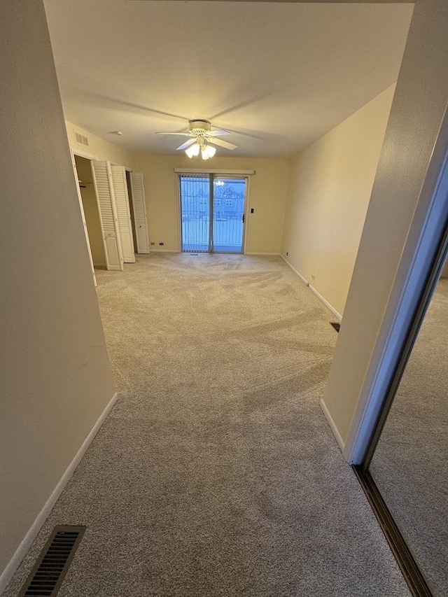 unfurnished room featuring ceiling fan and light carpet